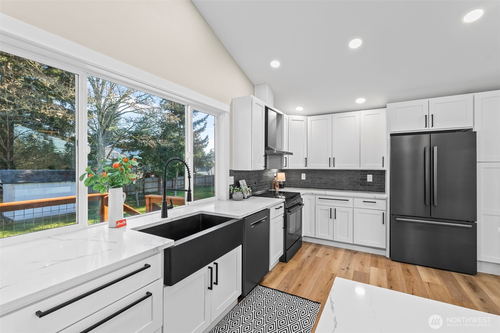 9844 Olson Road Northwest Silverdale, WA 98383 - Photo 12 of 38 a kitchen that has a sink stainless steel appliances a large window and a counter top space
