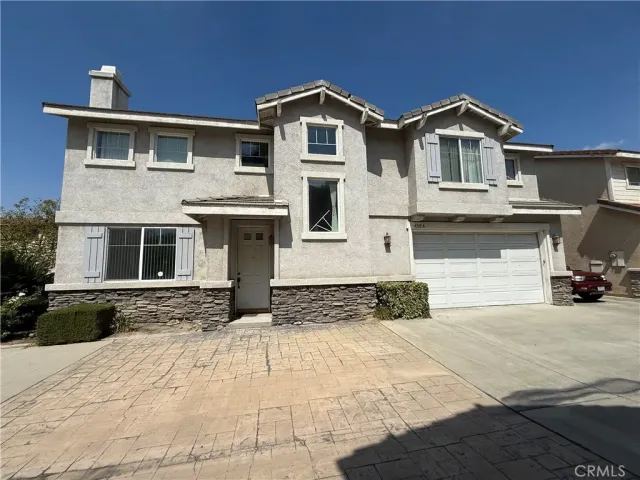 a front view of a house with yard and parking