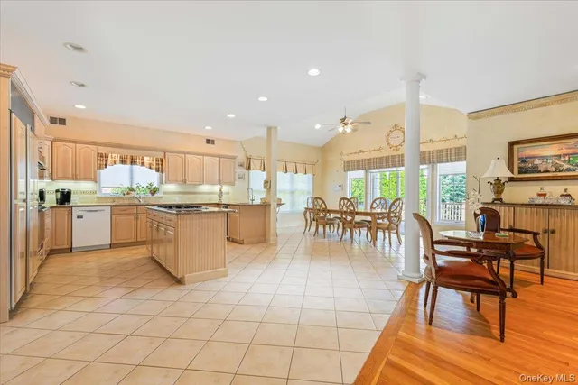 a kitchen with stainless steel appliances kitchen island granite countertop a stove a sink a dining table and chairs