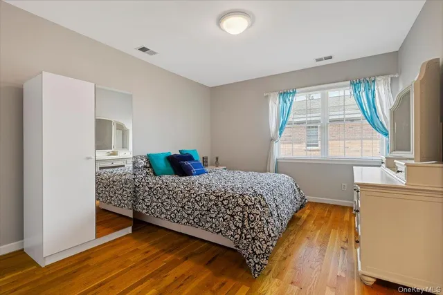 a bedroom with a bed wooden floor and window