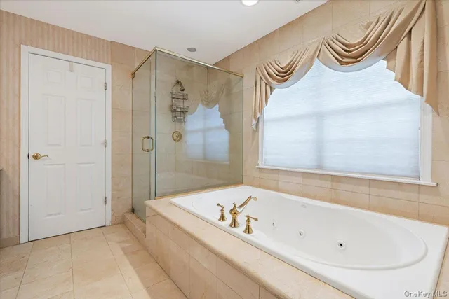 a spacious bathroom with a granite countertop sink a mirror and a bathtub