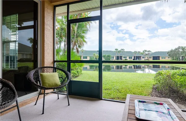 a view of a chair and tables in the patio next to a yard