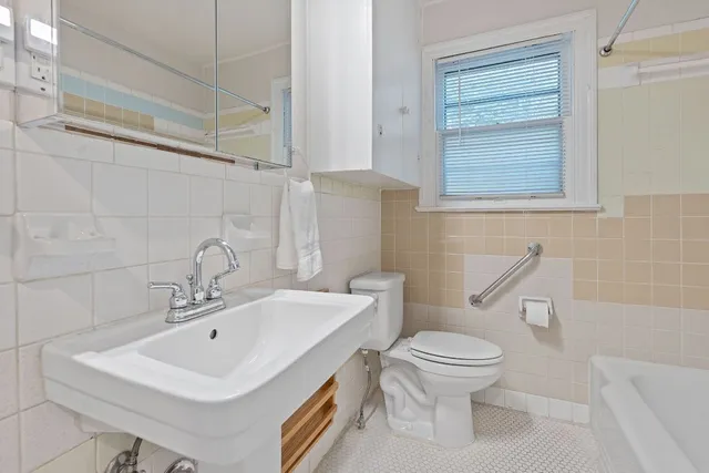 a bathroom with a sink a toilet and a mirror