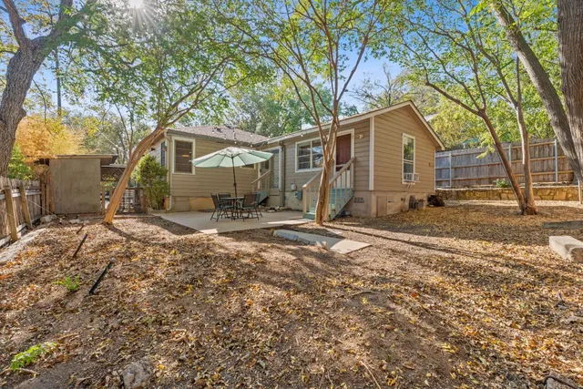 a view of a house with a yard covered in the forest