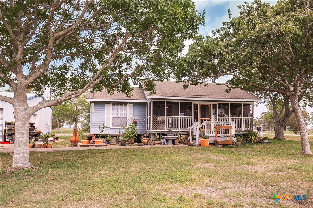 802 Bay Street Austwell, TX 77950 - Photo 2 of 27 a front view of a house with patio swimming pool and outdoor seating