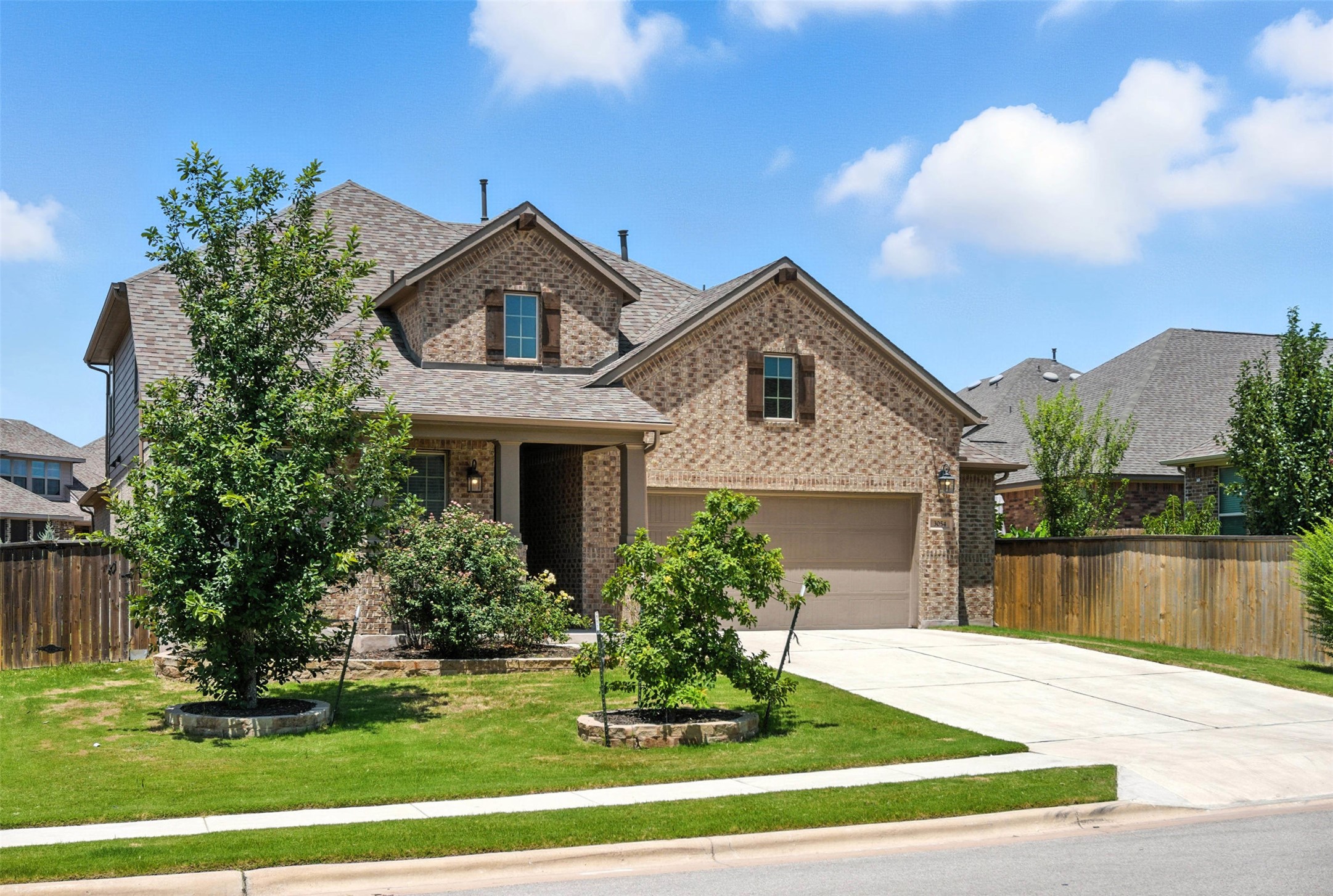 3054 Columbus Loop Round Rock, TX 78665 - Photo 2 of 40 View of front of house with brick siding, roof with shingles, a garage, and concrete driveway