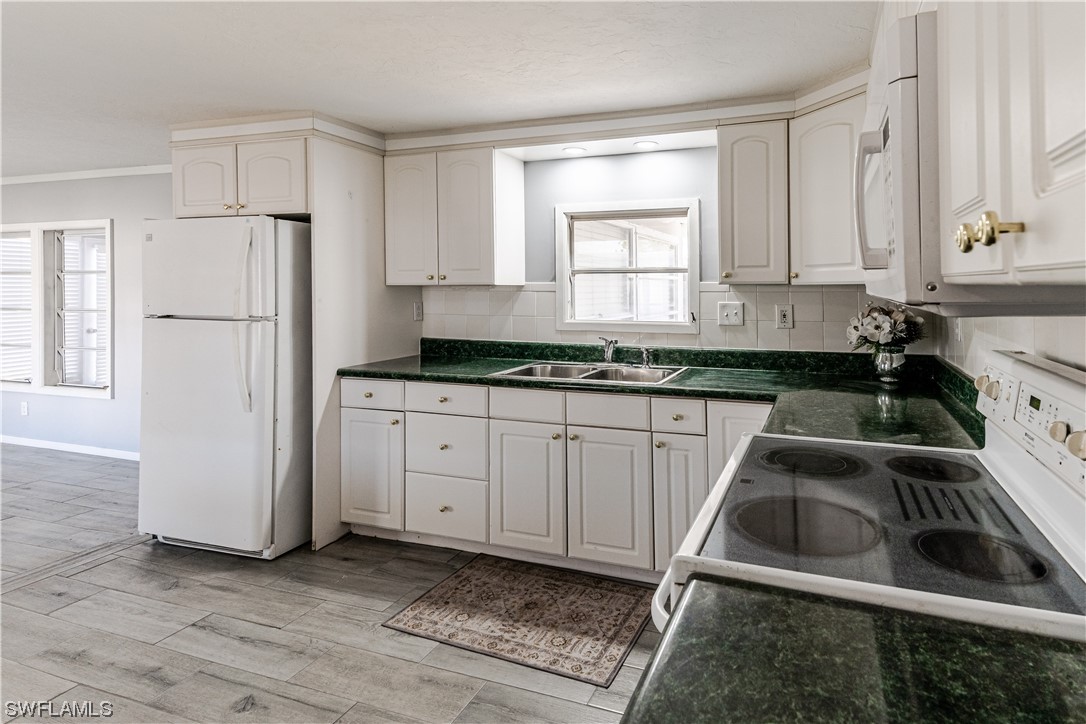 153 Cape Sable Drive Naples, FL 34104 - Photo 11 of 35 a kitchen that has a sink and a stove in it