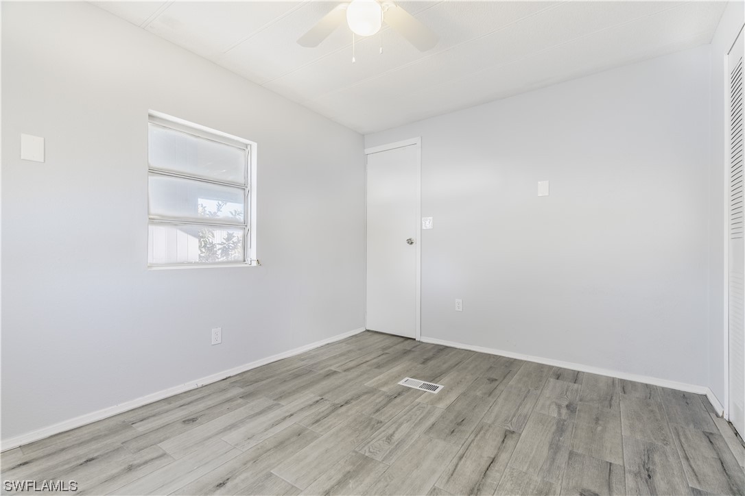 153 Cape Sable Drive Naples, FL 34104 - Photo 15 of 35 an empty room with wooden floor and windows
