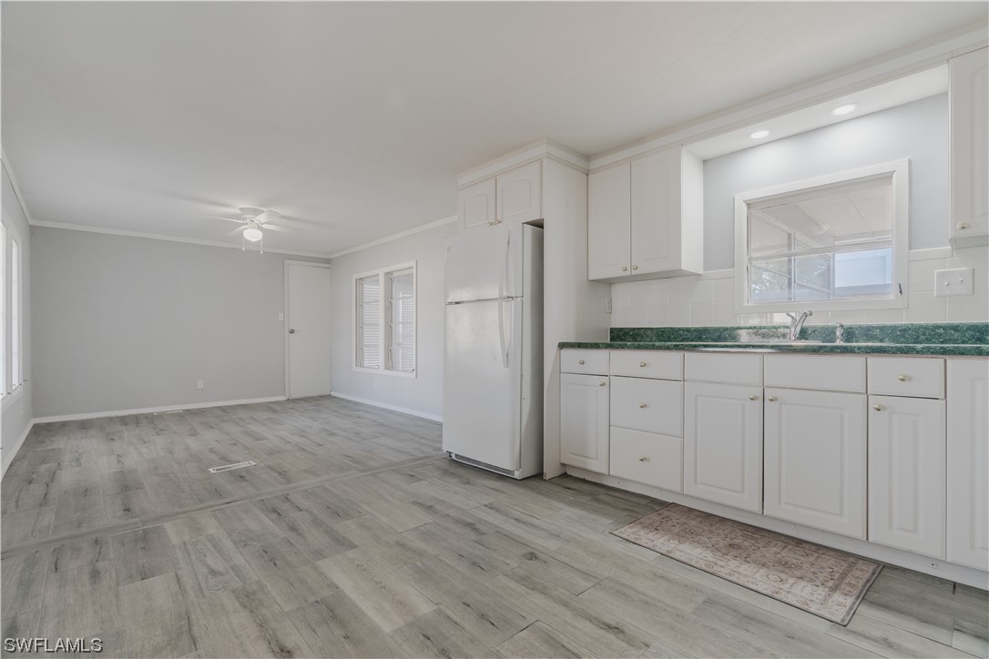 153 Cape Sable Drive Naples, FL 34104 - Photo 16 of 35 a view of a kitchen with white cabinets and wooden floor