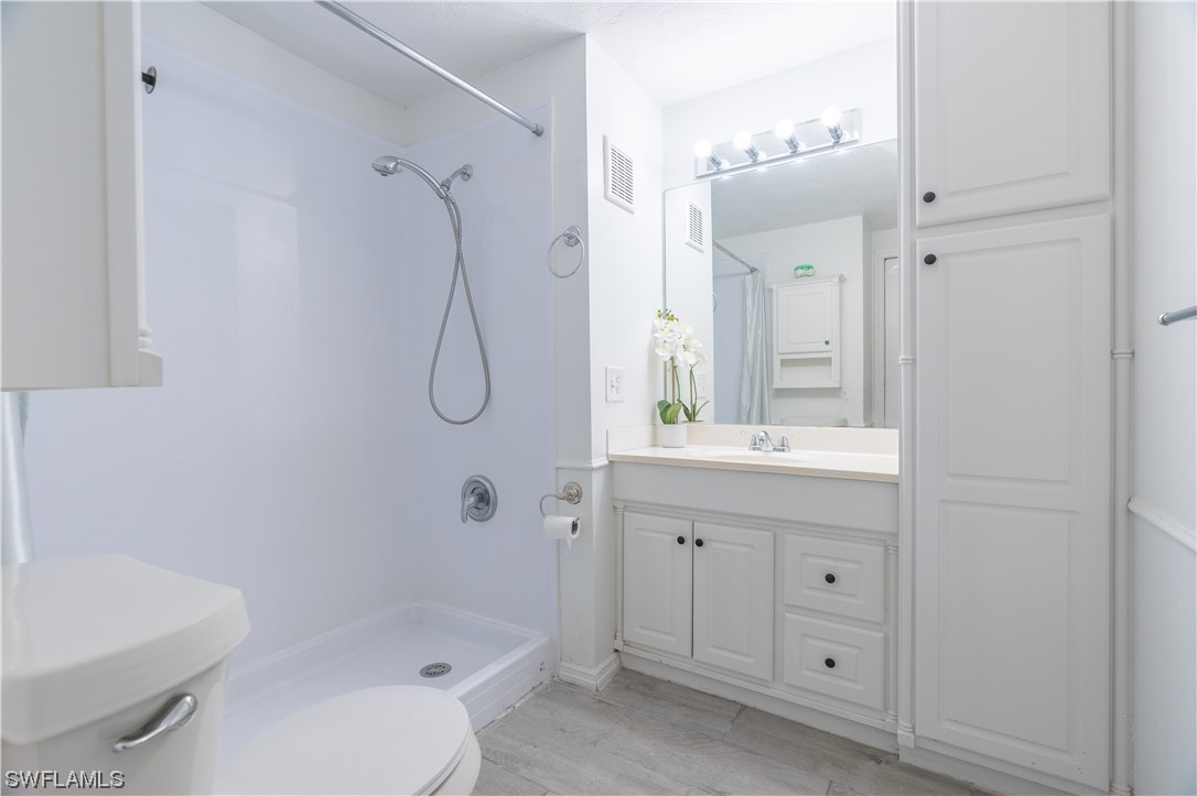 153 Cape Sable Drive Naples, FL 34104 - Photo 17 of 35 a bathroom with a granite countertop sink a toilet and a mirror