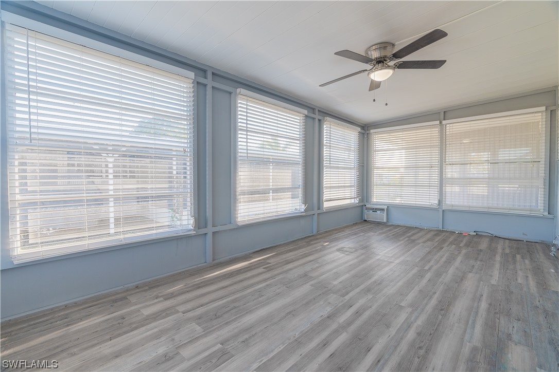 153 Cape Sable Drive Naples, FL 34104 - Photo 20 of 35 a view of an empty room with a window and wooden floor