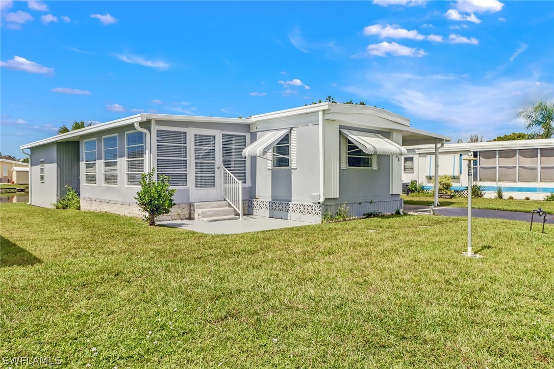 153 Cape Sable Drive Naples, FL 34104 - Photo 2 of 35 a front view of a house with garden