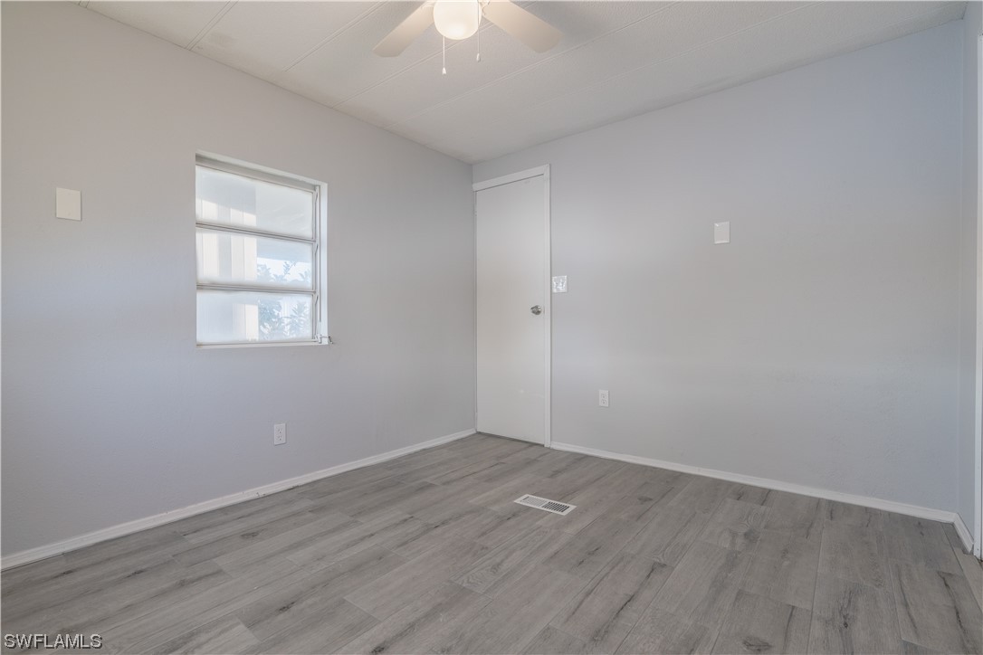 153 Cape Sable Drive Naples, FL 34104 - Photo 22 of 35 an empty room with wooden floor and windows