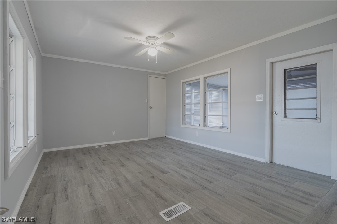 153 Cape Sable Drive Naples, FL 34104 - Photo 23 of 35 a view of an empty room with wooden floor and a window