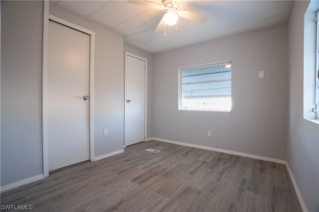 153 Cape Sable Drive Naples, FL 34104 - Photo 24 of 35 an empty room with wooden floor and windows