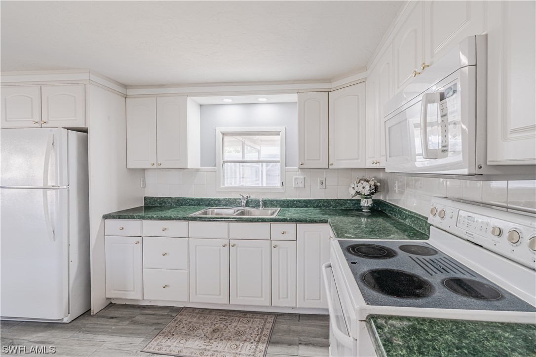 153 Cape Sable Drive Naples, FL 34104 - Photo 9 of 35 a kitchen with granite countertop a sink a stove and refrigerator
