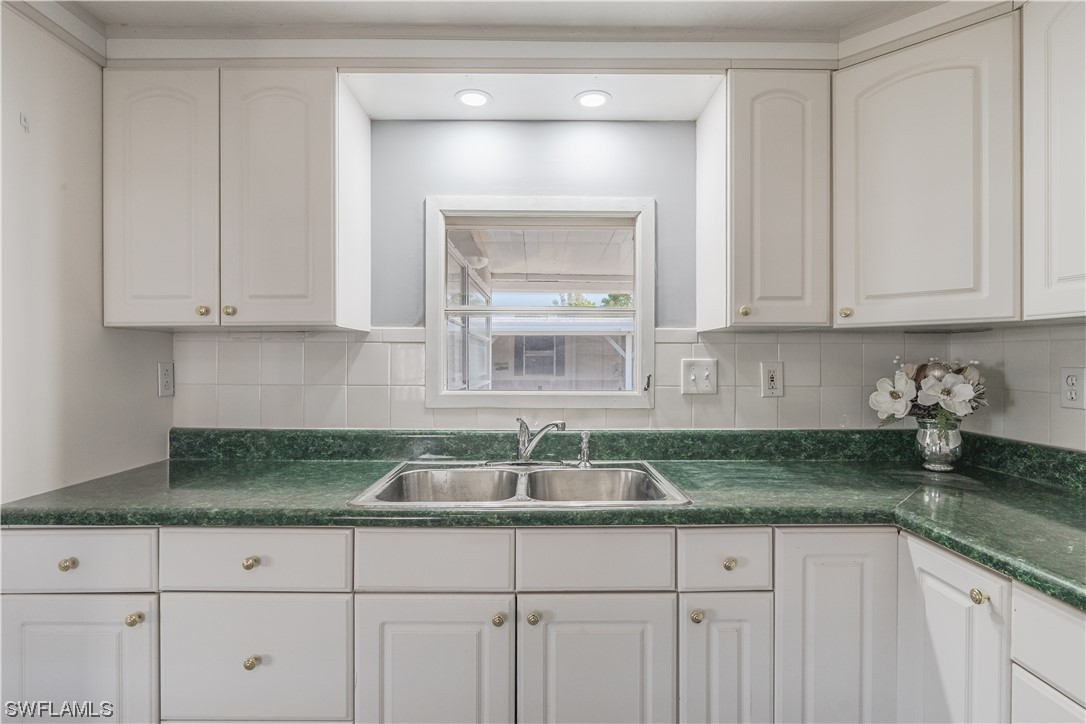 153 Cape Sable Drive Naples, FL 34104 - Photo 10 of 35 a kitchen with granite countertop white cabinets and a sink