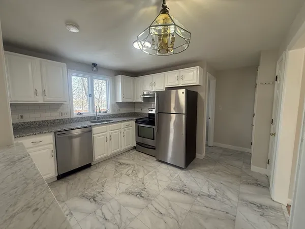 a kitchen with a refrigerator a stove a sink and cabinets