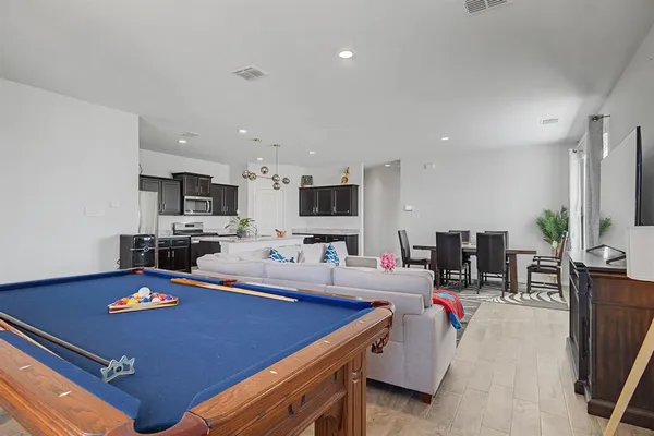 a room with furniture pool table and flat screen tv