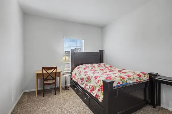 a bedroom with a bed and a lamp on table