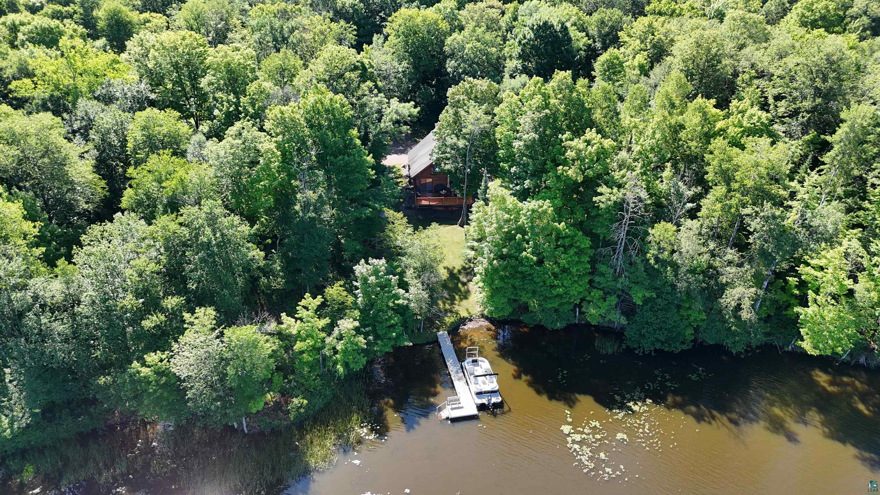 4613 North Lake Winter Road Winter, WI 54896 - Photo 65 of 73 Wood-sided residence situated among mature trees, featuring a private dock extending into the water