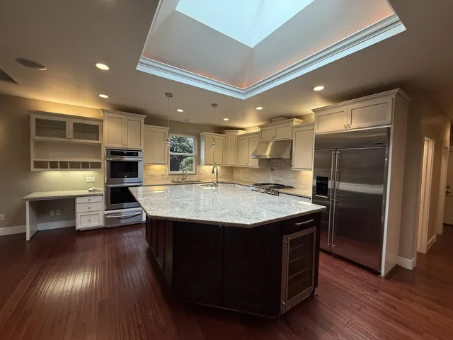 a kitchen with kitchen island granite countertop a stove and a refrigerator