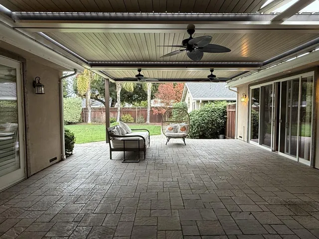 a roof deck with table and chairs and potted plants
