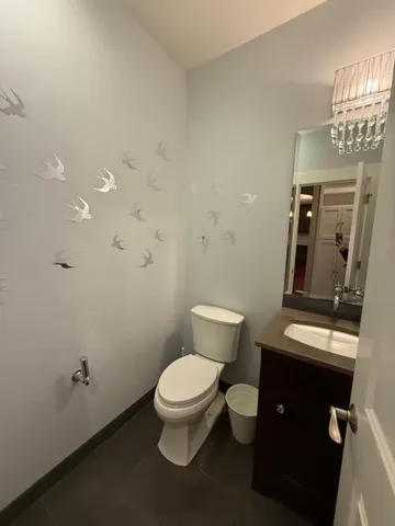 a white toilet sitting next to a bathroom sink and vanity