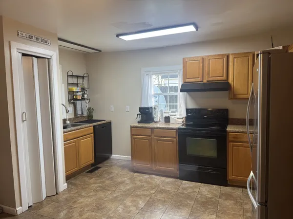 a kitchen with granite countertop a refrigerator stove and sink