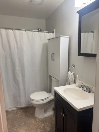a bathroom with a sink a toilet and a mirror