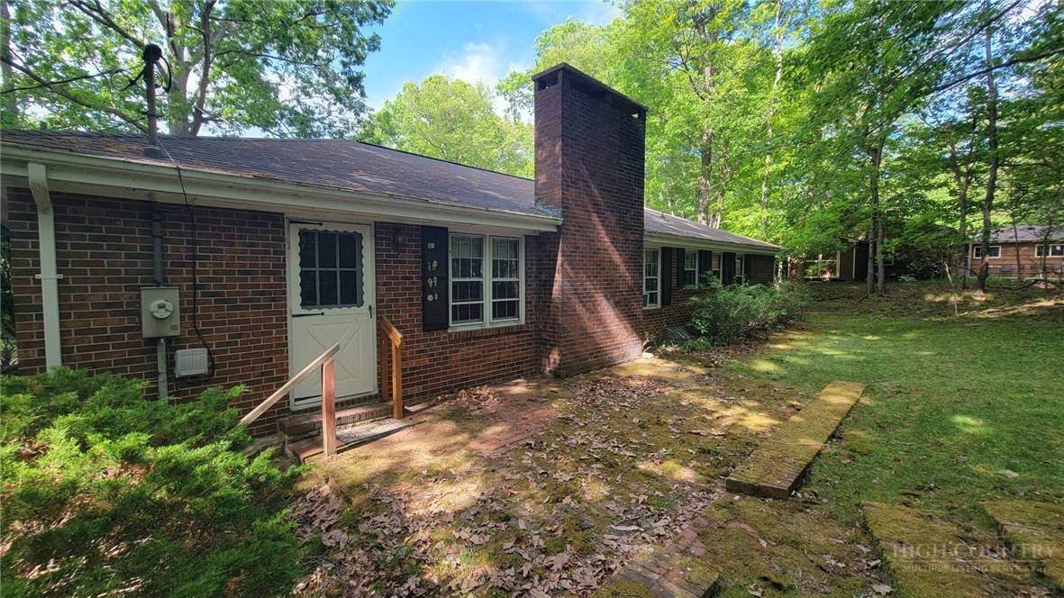 247 Crest Drive Boone, NC 28607 - Photo 17 of 19 a view of a backyard with plants and large tree
