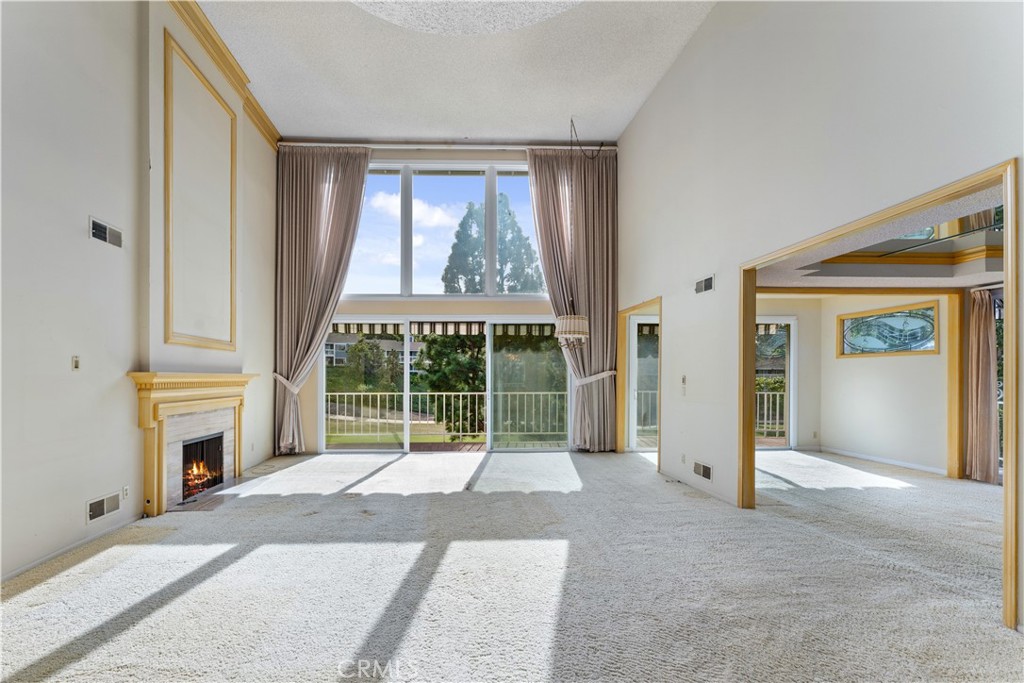 1 Rue Du Parc Newport Beach, CA 92660 - Photo 21 of 49 an empty room with floor to ceiling windows and a fireplace