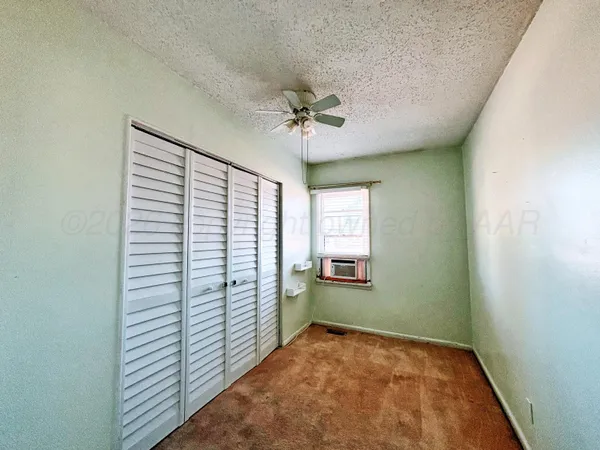 a view of a room with window and a ceiling fan