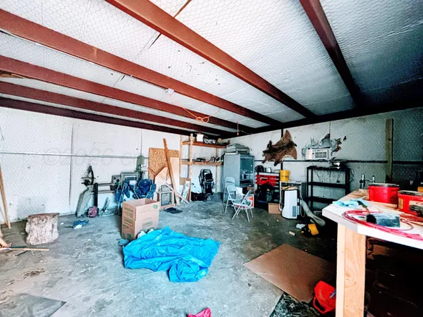 a living room with lots of furniture and clutter