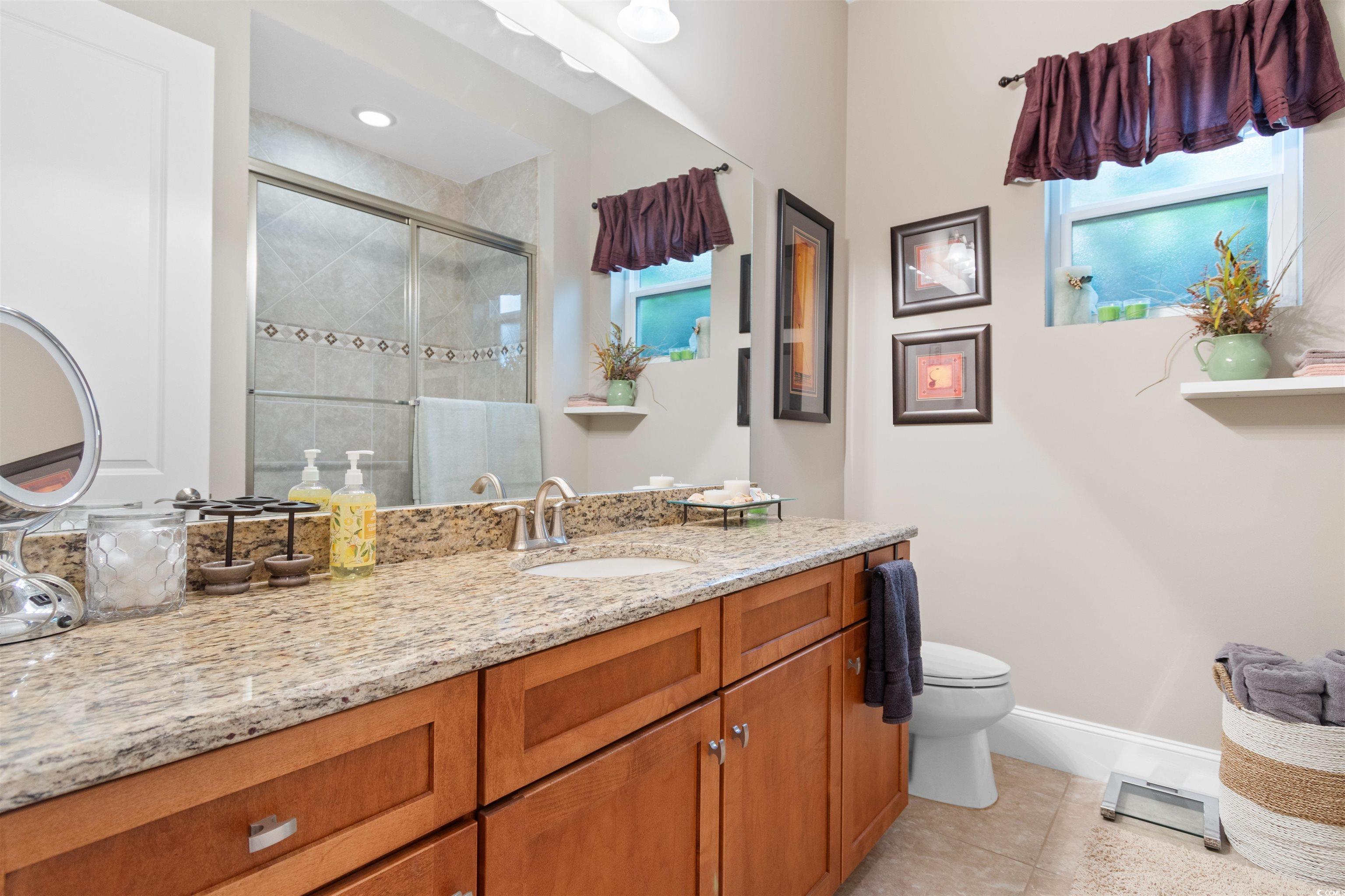 7253 Seville Drive Myrtle Beach, SC 29572 - Photo 26 of 39 Full bathroom with a stall shower, baseboards, vanity, tile patterned floors, and toilet