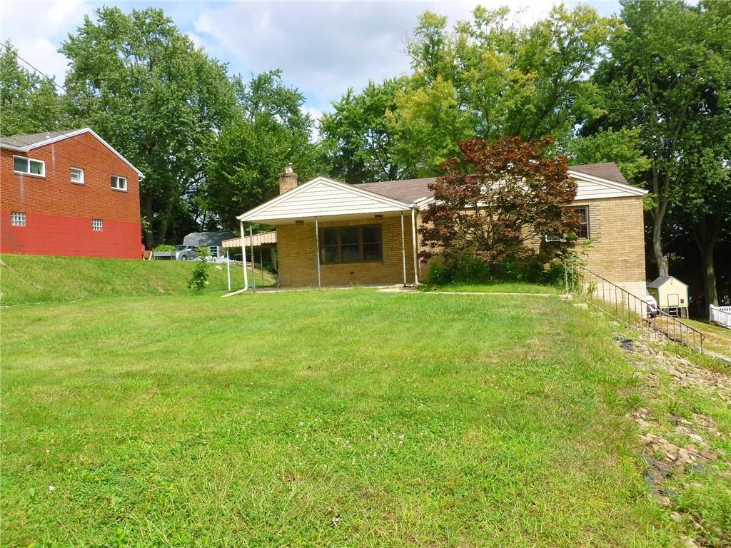 a front view of a house with yard and green space