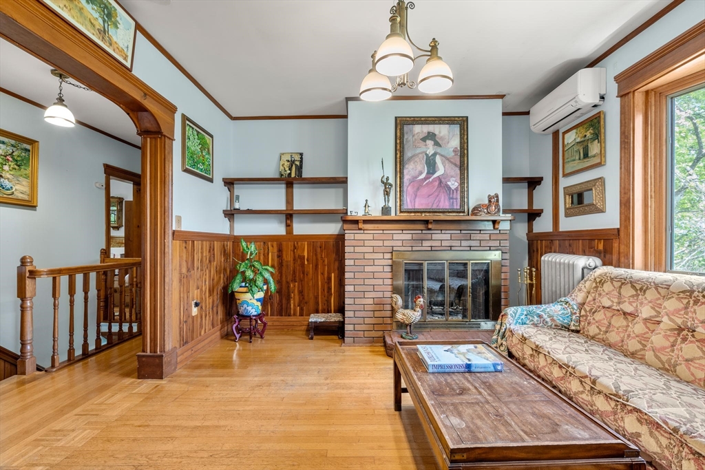 511 Beech Street Boston, MA 02131 - Photo 6 of 14 a living room with furniture a fireplace and a chandelier