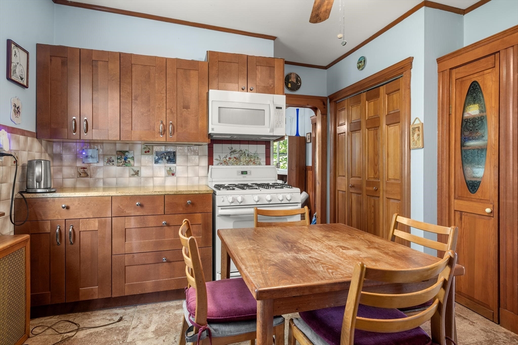 511 Beech Street Boston, MA 02131 - Photo 9 of 14 a kitchen with stainless steel appliances sink refrigerator and dining table