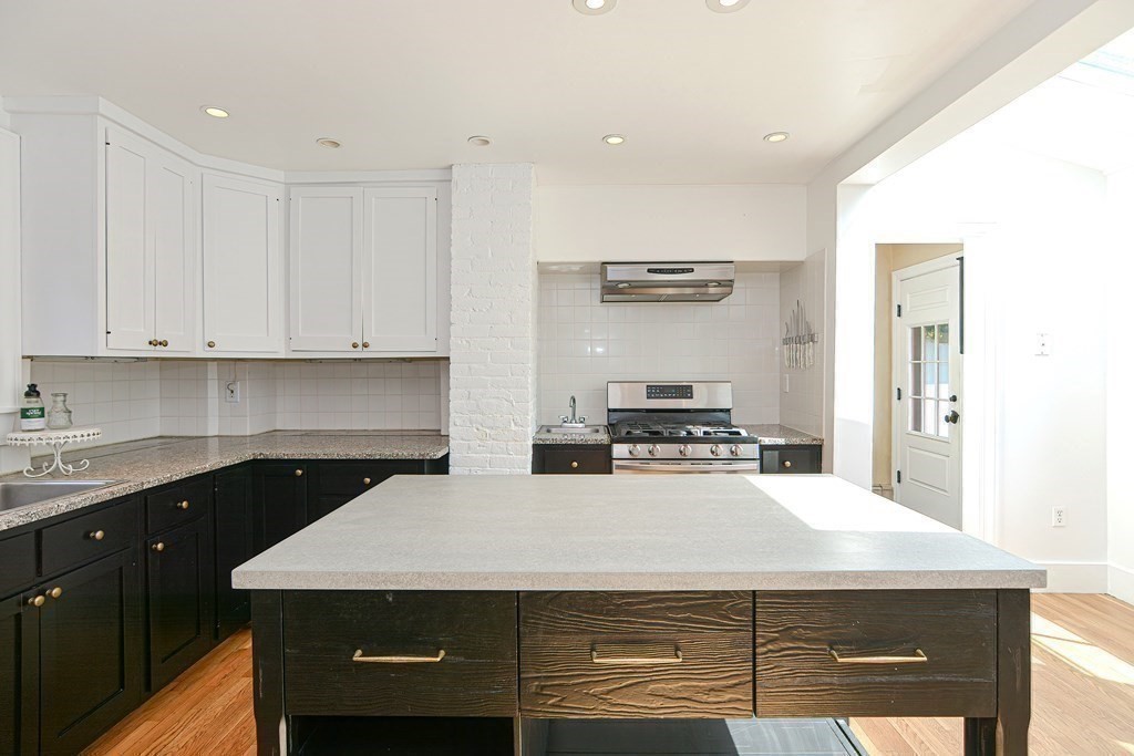 53 Frairy Street Medfield, MA 02052 - Photo 6 of 42 a kitchen with kitchen island a sink a stove and white cabinets