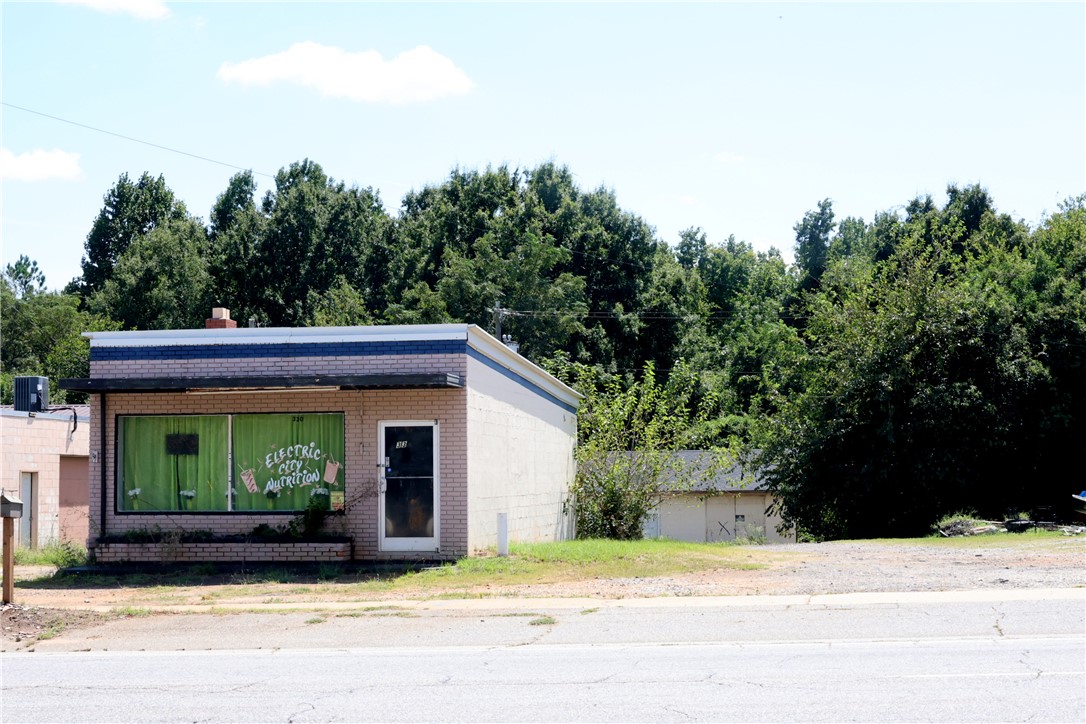 330 East Shockley Ferry Road Anderson, SC 29624 - Photo 2 of 2 Mature trees frame a classic brick-front commercial building situated alongside a paved roadway.