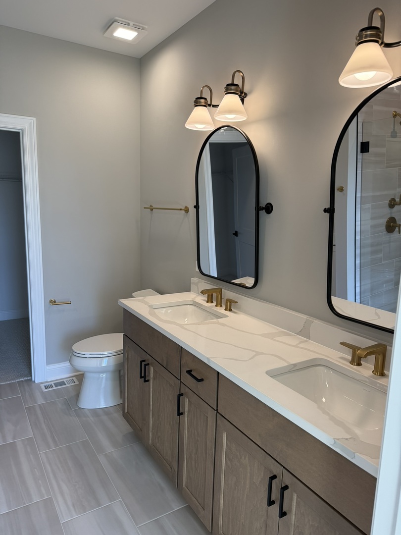 1204 Prairie Lane Lemont, IL 60439 - Photo 8 of 29 a bathroom with a granite countertop toilet sink and mirror