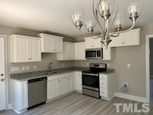 404 Pineview Road Clinton, NC 28328 - Photo 2 of 16 a kitchen with stainless steel appliances granite countertop a stove top oven a sink dishwasher and white cabinets with wooden floor
