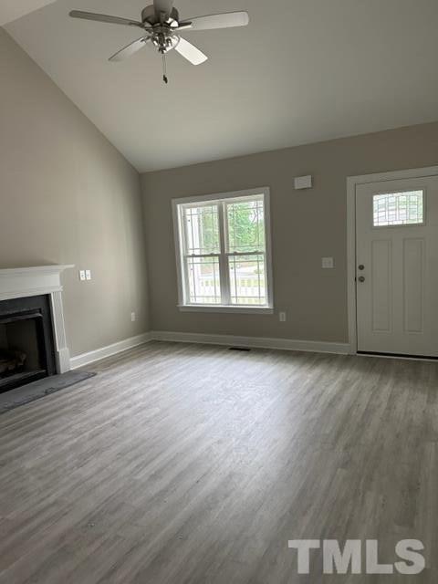 404 Pineview Road Clinton, NC 28328 - Photo 8 of 16 an empty room with wooden floor fireplace and windows