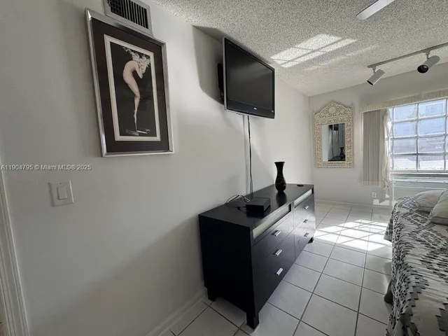 a hall way with furniture a flat screen tv and windows