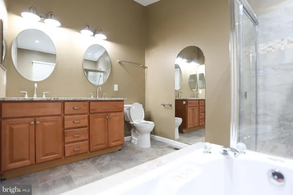 a bathroom with a granite countertop double vanity sinks and a mirror
