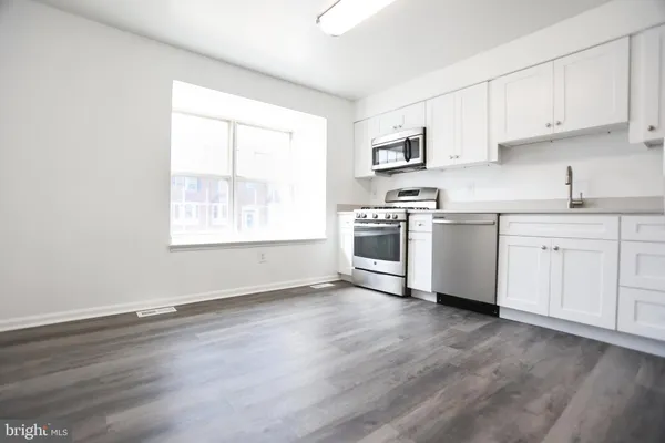 a kitchen with granite countertop white cabinets and white appliances