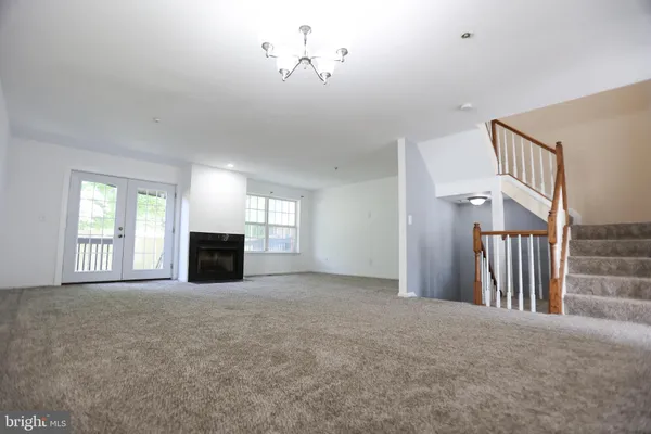 a view of an empty room with a fireplace and a window