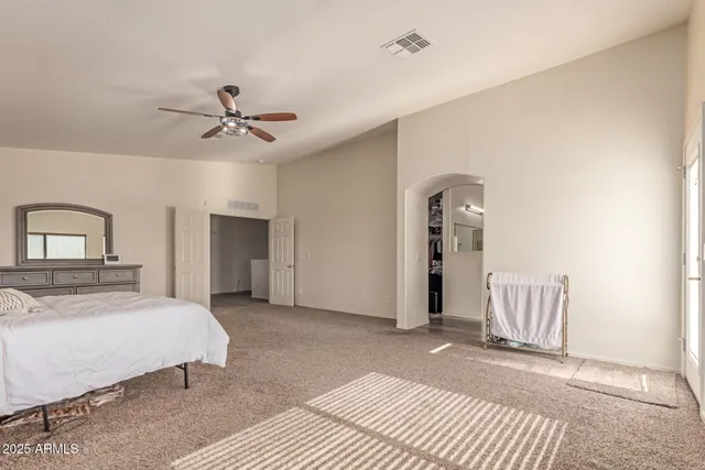 a spacious bedroom with a bed and a dresser