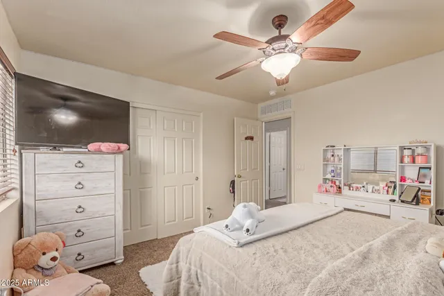 a bedroom with a bed and a flat tv screen on dresser