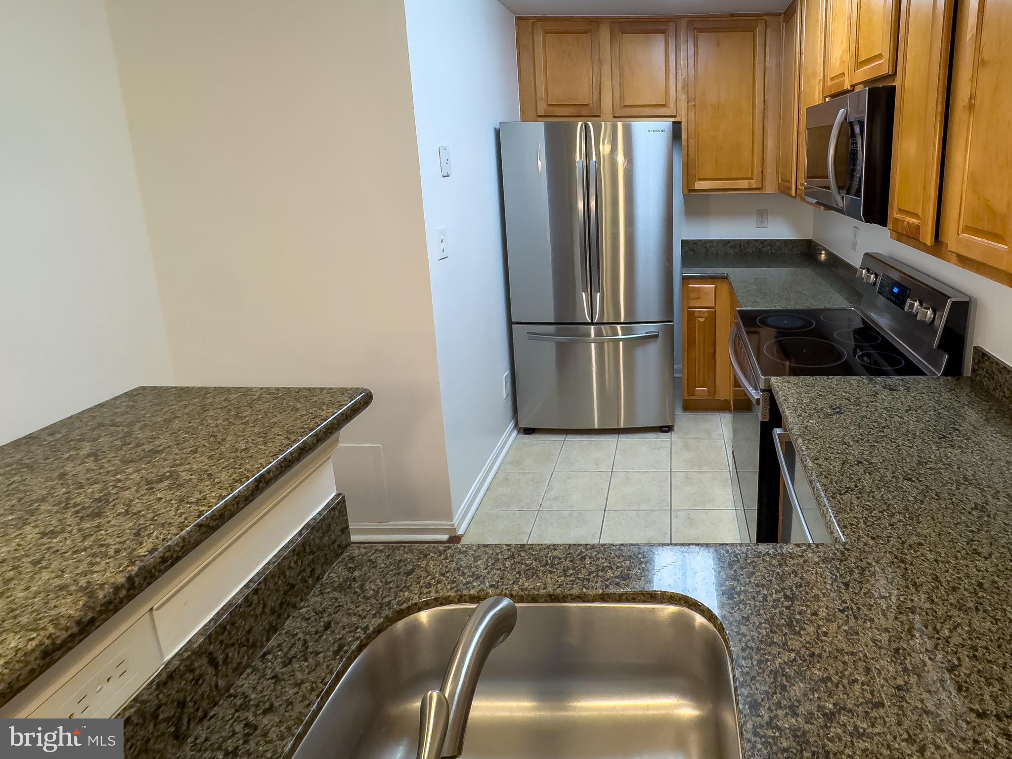 3178 Summit Square Drive, Unit 3C9 Oakton, VA 22124 - Photo 11 of 21 a kitchen with stainless steel appliances granite countertop a sink refrigerator and microwave